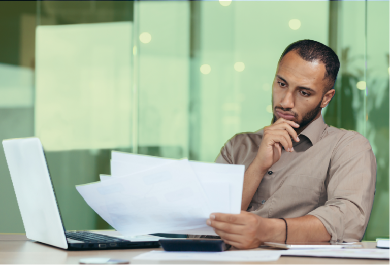 An employee is reviewing their termination notice while sitting at their desk.