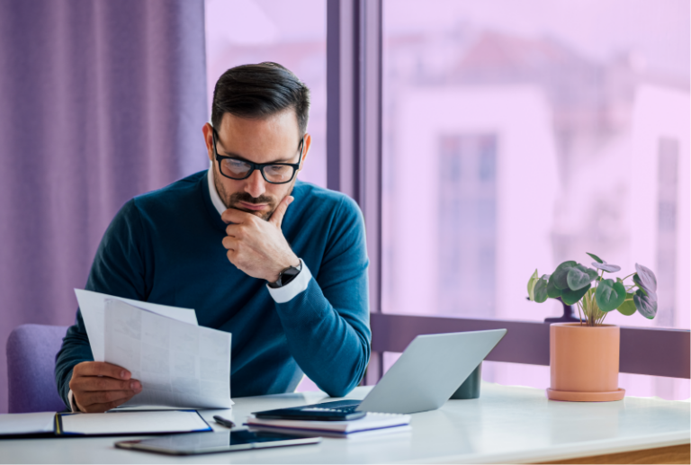 An employee is looking at a budget page at their desk. The look concerned.