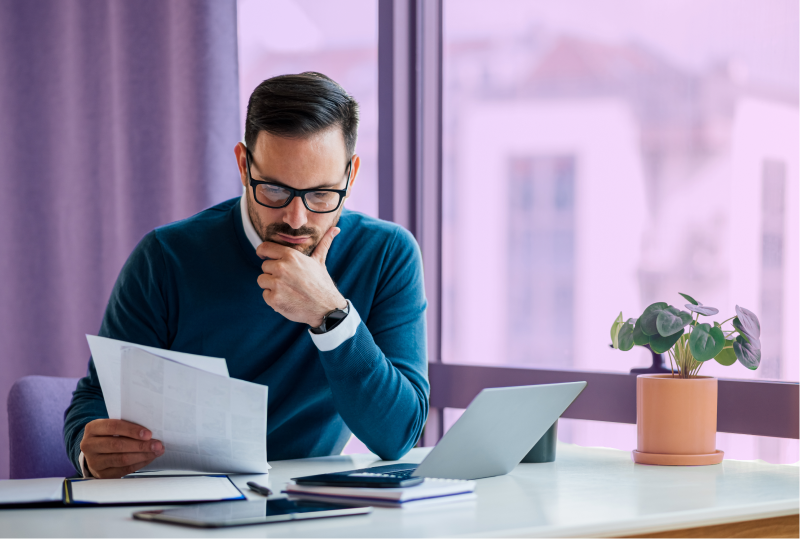 An employee is looking at a budget page at their desk. The look concerned.