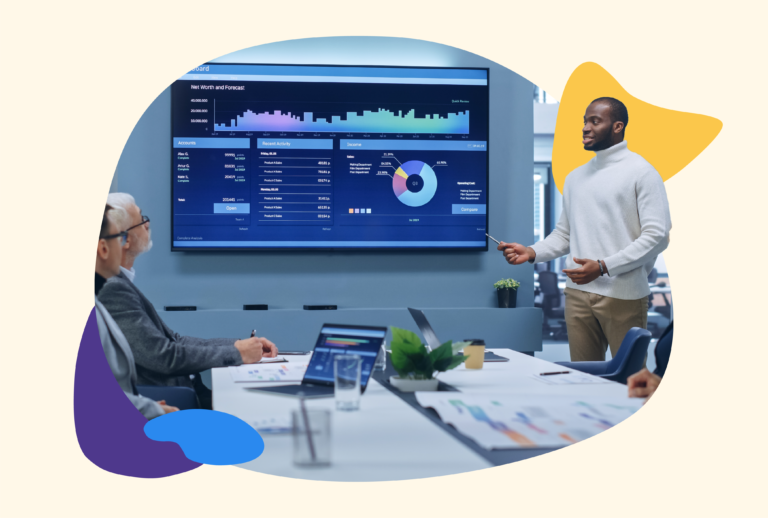 Three males in a meeting looking a data on screen together