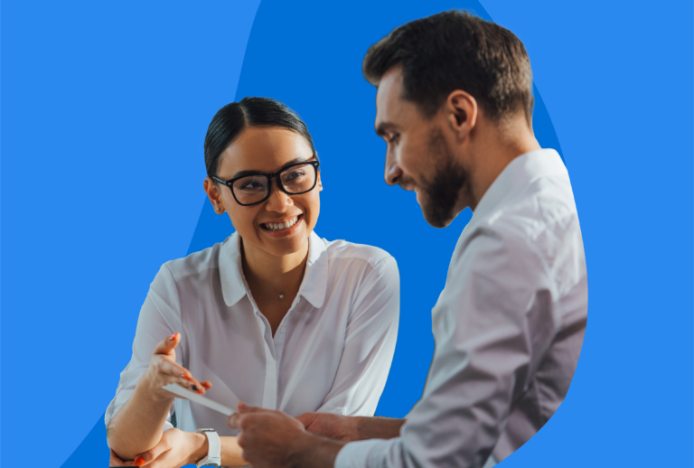 A male and female looking over a paper together, dressed in business attire