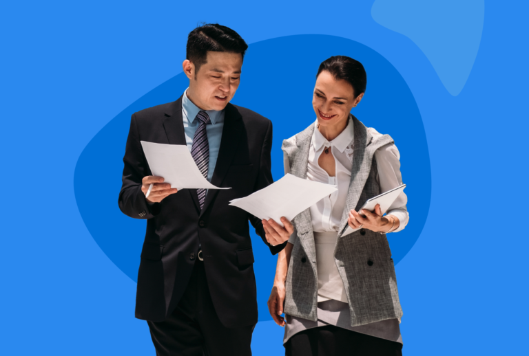 Two people smiling reading paperwork