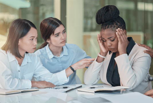 Woman feeling stressed being aided by friends