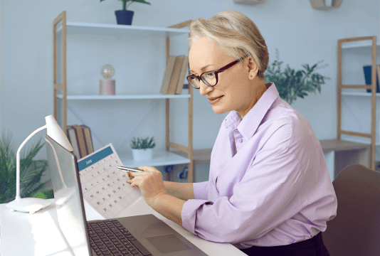 An employee is creating a DEI Calendar on a laptop