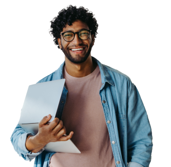 Young man holding a laptop smiling at camera in a cream shirt and denim button down shirt.
