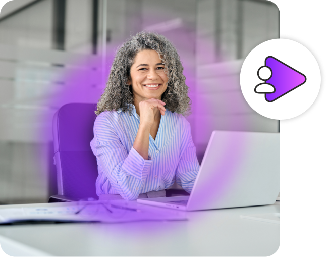Woman smiling in front of a laptop in business causal clothing.