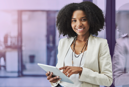 HR Trends 2025: An employee at an office is looking at HR Trends for 2025 on a tablet.