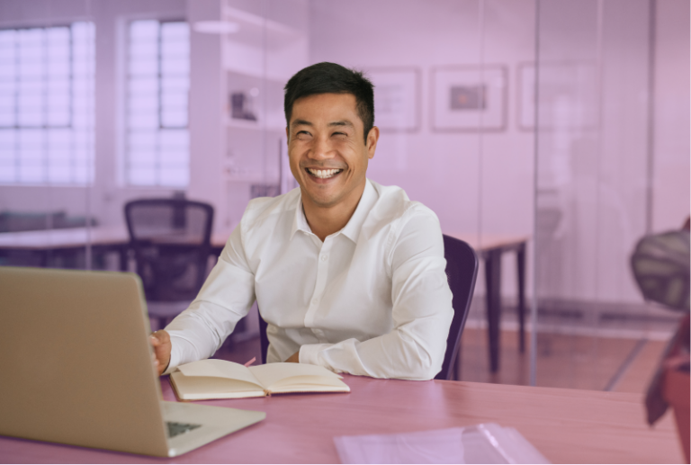A happy employee is sitting at their desk and has just received a performance review