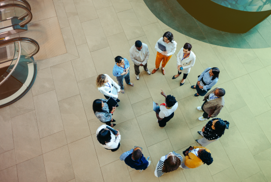 Employees are discussing their emergency preparedness plan while standing in a circle around a leader