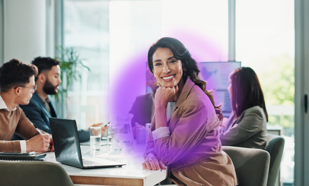 An employee is sitting at a desk, looking at the camera, with purple Citation Canada swirl icon around them.