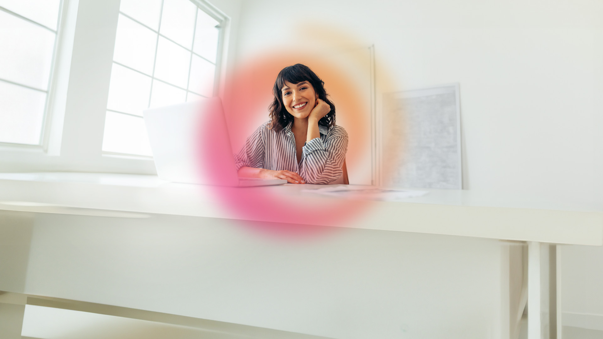 Image of a young woman smiling in a bright office.
