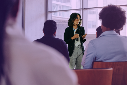 An employee is explaining an HR compliance change to other employees