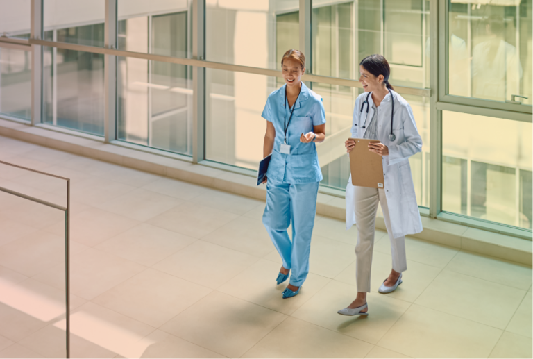A Doctor and a Health Professional are wallking and smiling in a Canadian Hospital Hallway