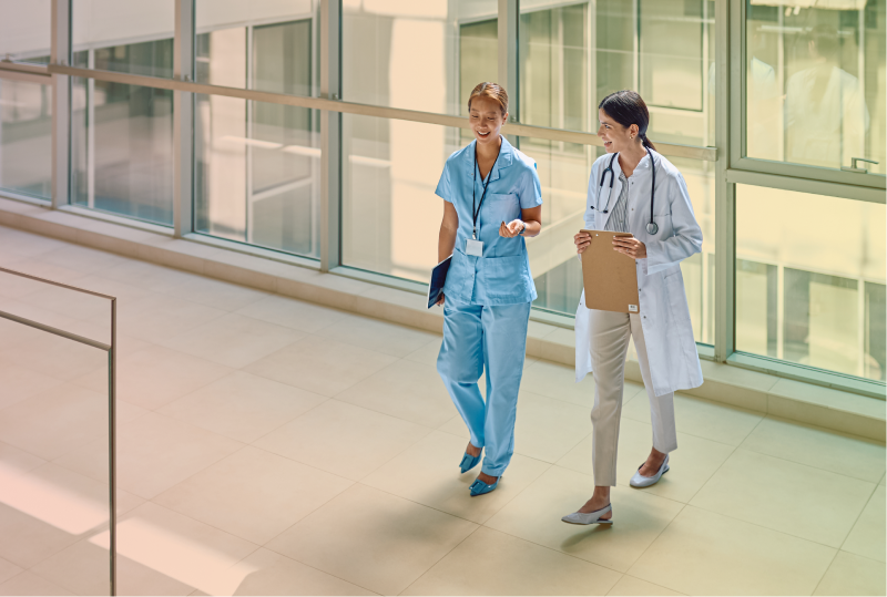 A Doctor and a Health Professional are wallking and smiling in a Canadian Hospital Hallway