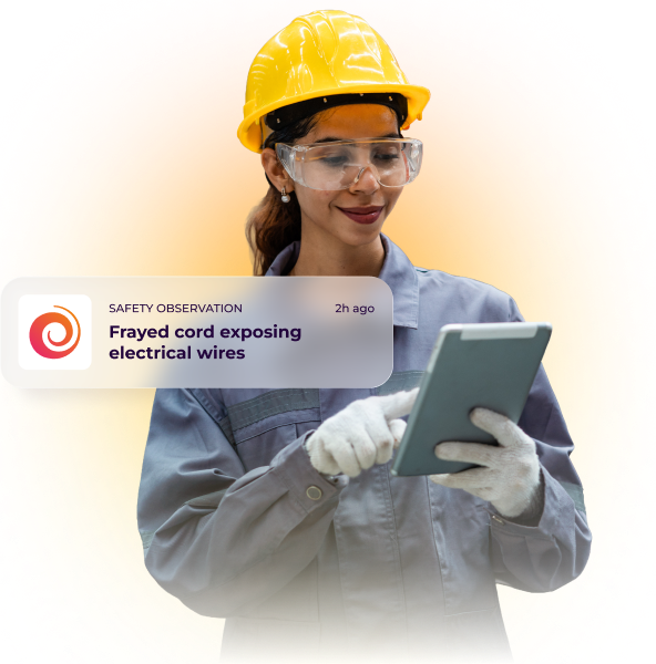 Worker in hardhat reporting a safety observation on a tablet