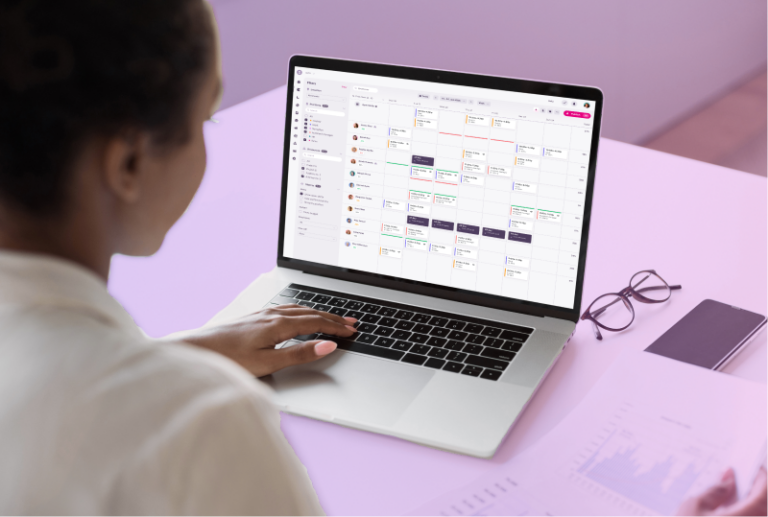 An employee is sitting at their desk, looking at Atlas Scheduling's calendar function and planning the next schedule.