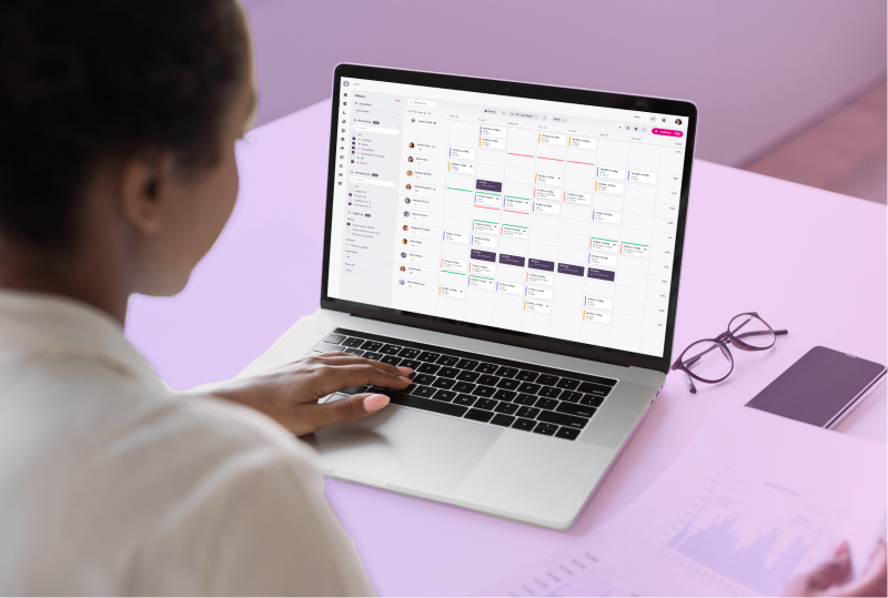 An employee is sitting at their desk, looking at Atlas Scheduling's calendar function and planning the next schedule.